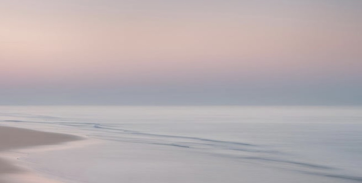 Plage paisible aux teintes roses et bleues